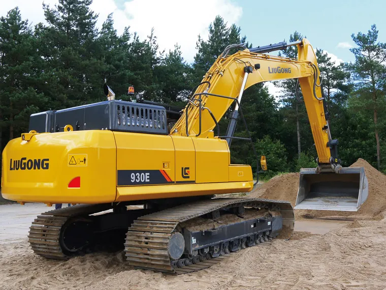 Excavadora LiuGong 930E vista trasera-lateral sobre un banco de arena entre árboles