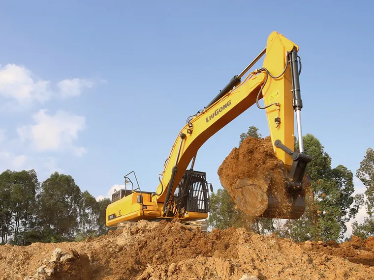 Excavadora LiuGong 930E excavando con el cucharón cargado de tierra y cielo azul